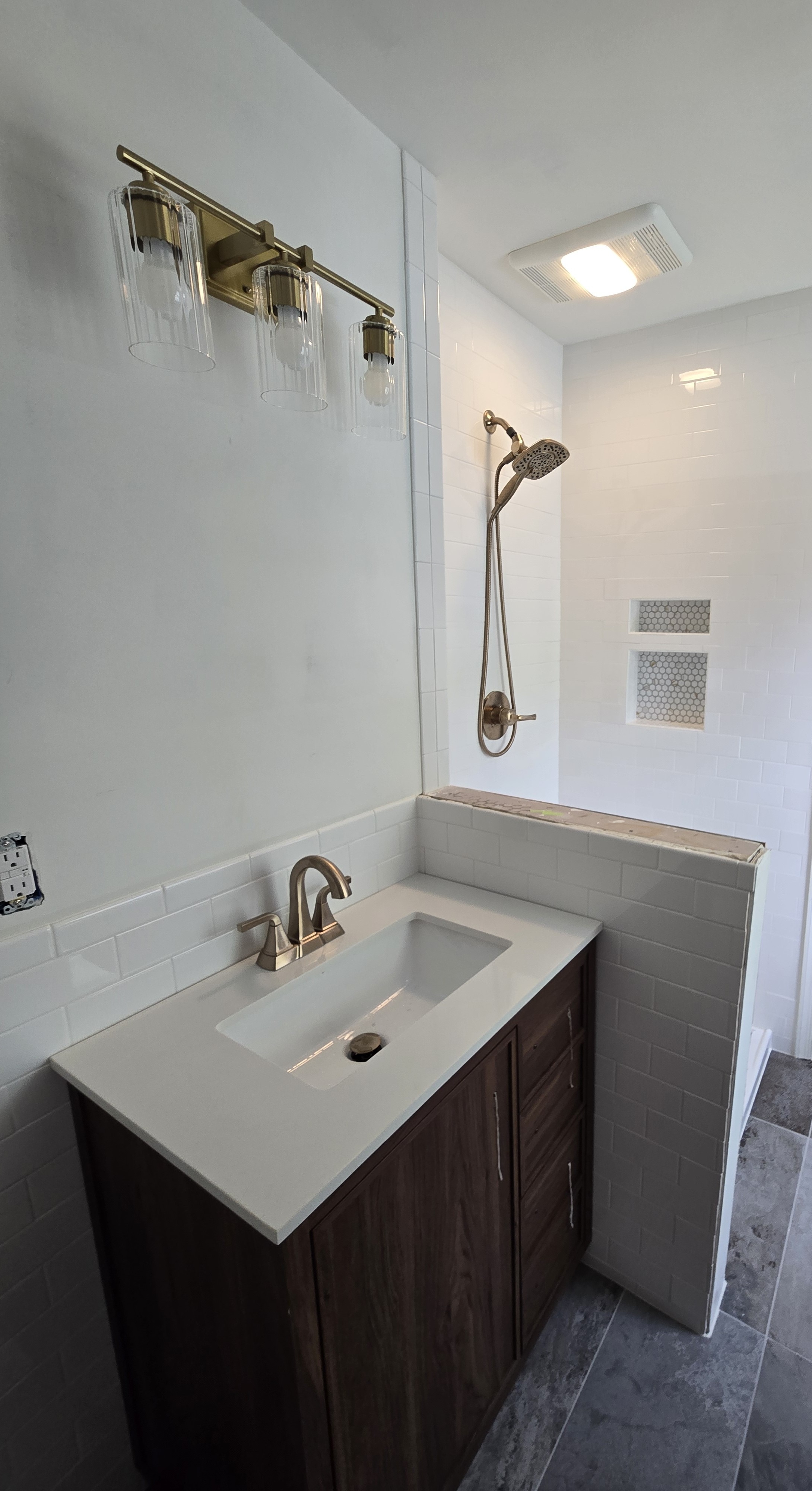 Bathroom remodel showing the vanity, shower tile, floor, and current progress